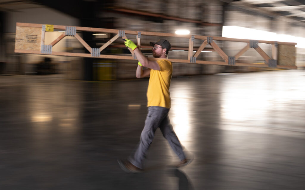 Man carrying building materials on shoulder
